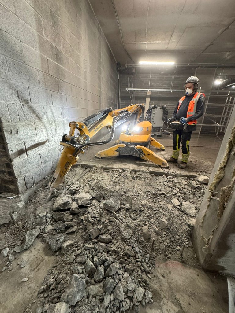 Brokk working through the slab with controlled breaking