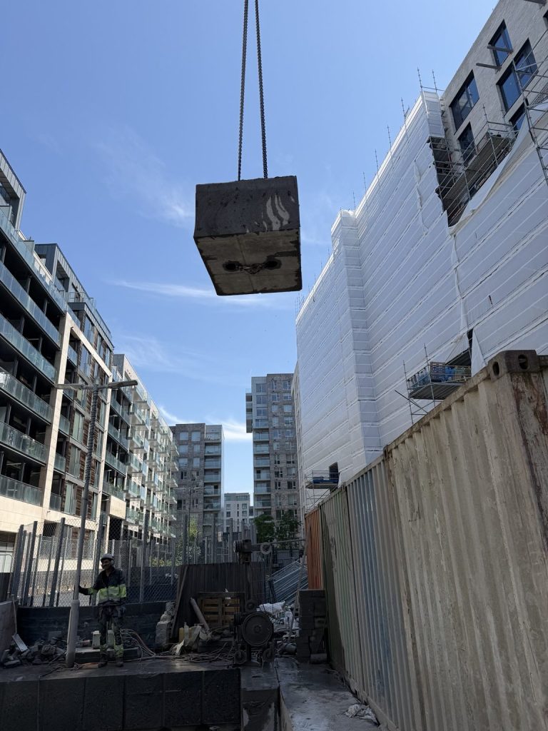 Crane lifting a cut concrete block clear of the structure on a Ralkore wire sawing job
