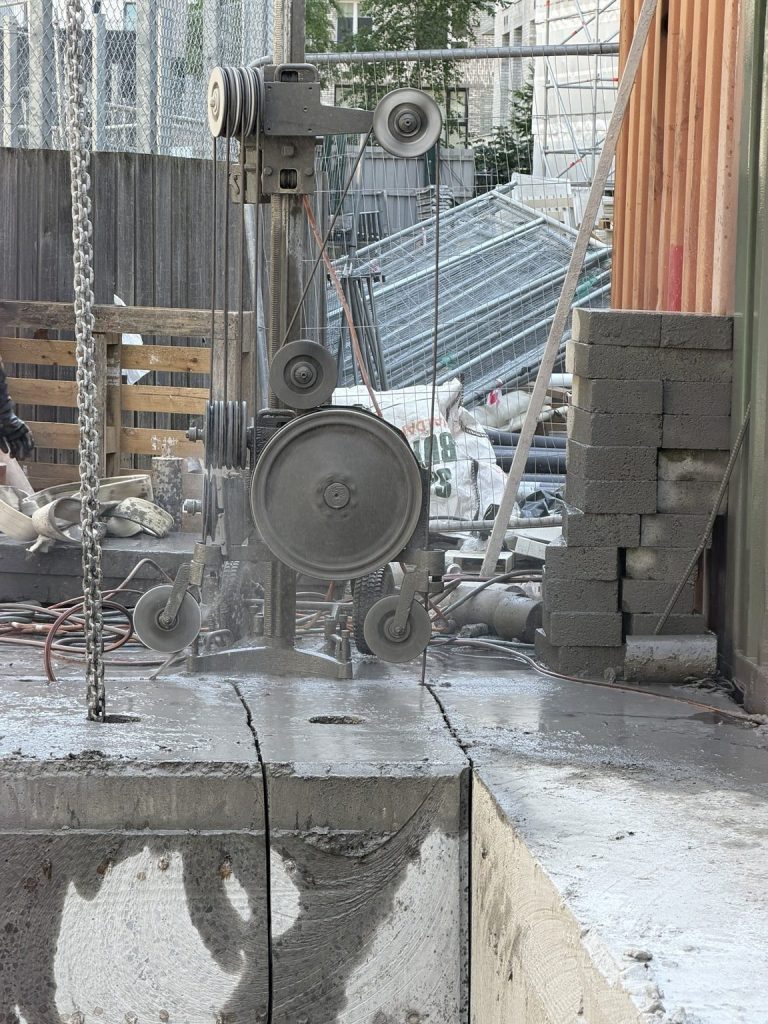 Diamond wire saw drive unit and guide pulleys cutting through a thick reinforced concrete section